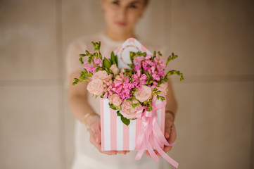 Hat box with flowers in girl's hands