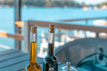 Olive oil and balsamic vinegar on a table and river background