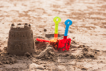 Castle sand and children's toy on the sand beach.Plastic bucket and shovel toy for kid play on the sea side. Travel on the beach concept