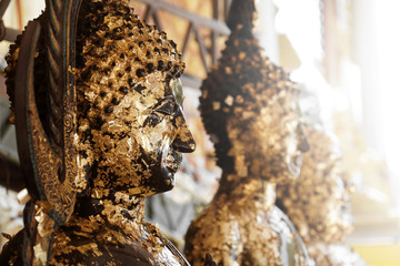 Naklejka na ściany i meble Black sacred buddha image statue gold leaves plates