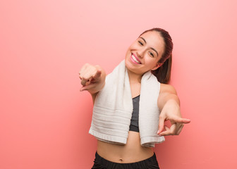 Young fitness woman cheerful and smiling pointing to front