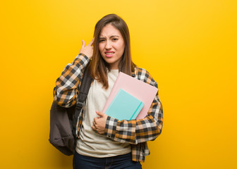 Young student woman doing a disappointment gesture with finger