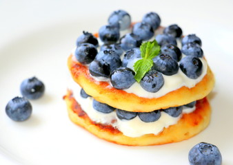  Romantic dessert with blueberries. Cheesecakes with cream and fresh berries.
