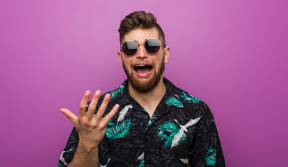 Obraz premium Young man wearing a vacation look screaming with rage.