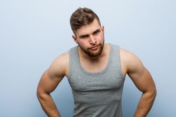 Young handsome fitness man scolding someone very angry.