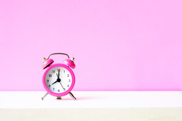 Pink alarm clock on pink background with coppy space
