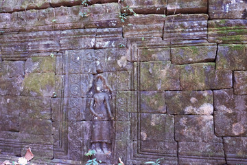 Antique stonework decorated with bas-relief. Stone carving. Ancient ruins overgrown with moss.