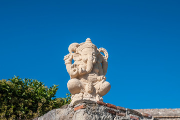 Fototapeta na wymiar Indian God of wisdom with an elephant's head on a blue sky background