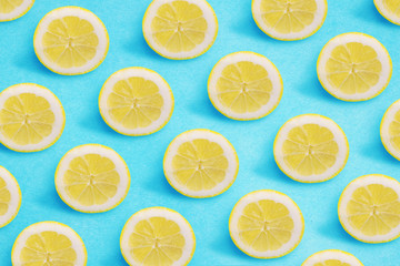 Lemon pattern on a bright blue background. Flat lay summer concept.