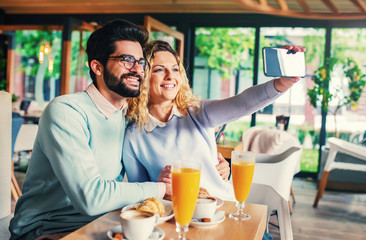 Young couple sitting in a cafe, having breakfast. Love, dating, food, lifestyle concept