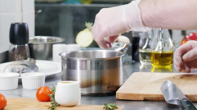 Restaurant kitchen. Adding seafood ingredients in the bouillon