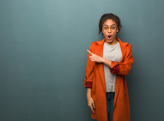 Young black african american girl with blue eyes pointing to the side