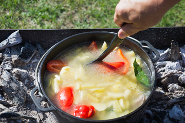 Process cooking shurpa soup in a large cast-iron cauldron outdoor. Turkish cuisine.