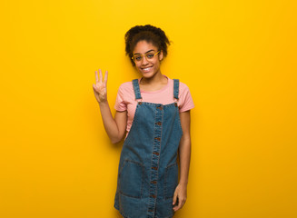 Young black african american girl with blue eyes showing number three