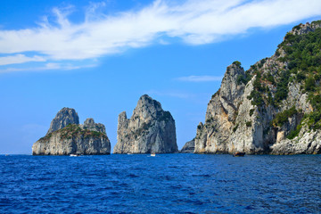 View from the sea of the coastline of the island of Capri with the Faraglioni sea stacks, Italy