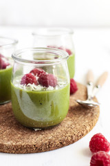 White chocolate cream mousse with matcha, avocado, pistachio, fresh raspberries - healthy vegan dairy free, gluten free