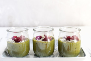 White chocolate cream mousse with matcha, avocado, pistachio, fresh raspberries - healthy vegan dairy free, gluten free