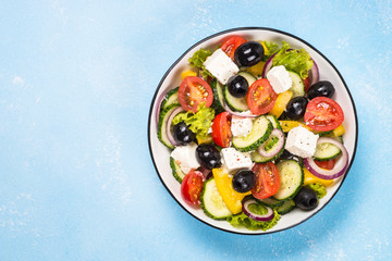 Greek salad on blue table.