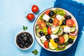 Greek salad on blue table.