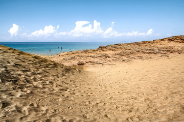 Beach background of free space and summer day. Hot yellow sand and blue sky. 