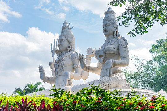 lord shiv & parvati statue at an indian garden looking awesome with small shrubs.