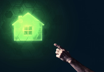 Conceptual image with hand pointing at house or main page icon on dark background