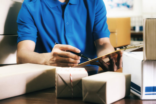 Courier checke the delivery receipt list in office.