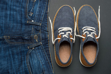Men's casual outfits for man clothing with classic jeans and denim shoes on dark background. Fashion and style concept, flat lay, top view, copy space for text.