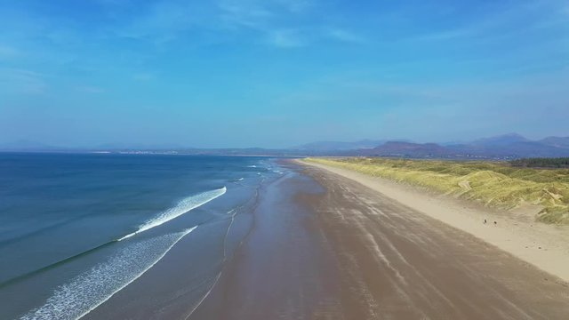 Aerial flight over the coastline of Harlech with beautiful beach and sand dunes