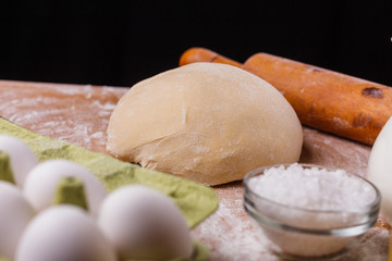 Fototapeta na wymiar young woman in apron kneading dough on board