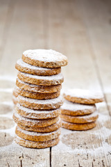 Fresh oat cookies with sugar powder closeup on rustic wooden table.