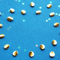 Texture and background Golden confetti and transparent stars on a light blue textural background. Space for text..