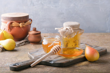 Jars of honey and pears on the table.