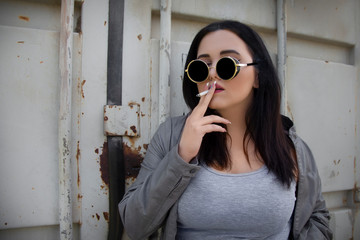 women in depression smoking a cigarette, woman in trendy round sunglasses