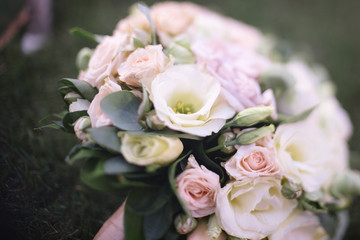 beautiful wedding bouquet of white flowers lies on the grass