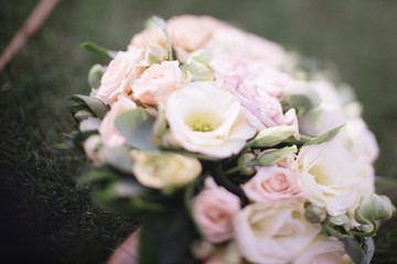 beautiful wedding bouquet of white flowers lies on the grass