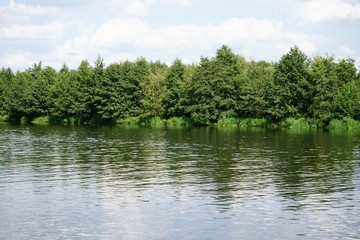 Sonnige, idyllische Flusslandschaft mit grünem Wald am Berliner Mauerweg in Hennigsdorf