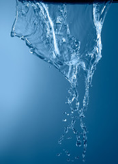 Fototapeta na wymiar blue color water splash isolated on empty background, studio photo