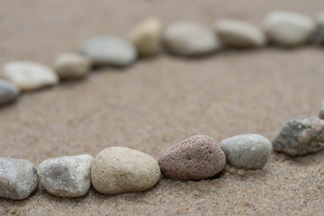 Fototapeta na wymiar lines of pebbles on sand macro