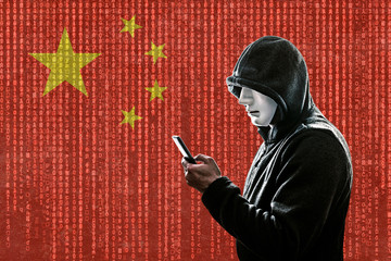 Chinese hooded hacker with mask holding smartphone 