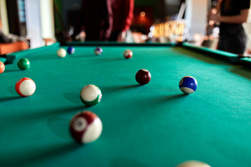 Billiard balls on table with people in background