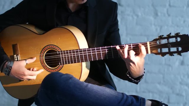 close-up of guitar strings and fingerboard, guitarist plays flamenco on acoustic guitar