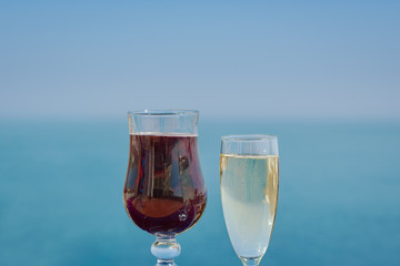 Flutes of wine are standing on the table against wonderful ocean background.