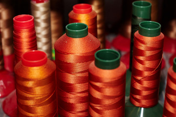 Different, colorful sewing threads, for leather parts, arranged on a shelf, used in the production of shoes, handbags