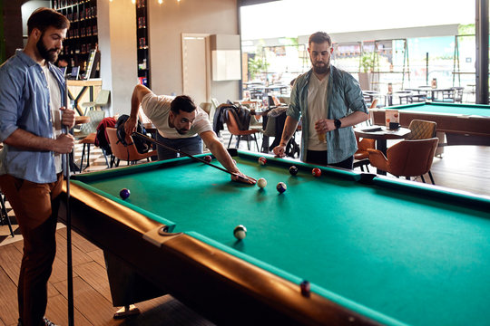 Friends playing billiards together