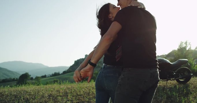 In a windy summer time couple arrived with their motorcycle in amazing place with a beautiful landscape.