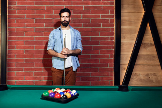 Portrait of serious man at billiard table