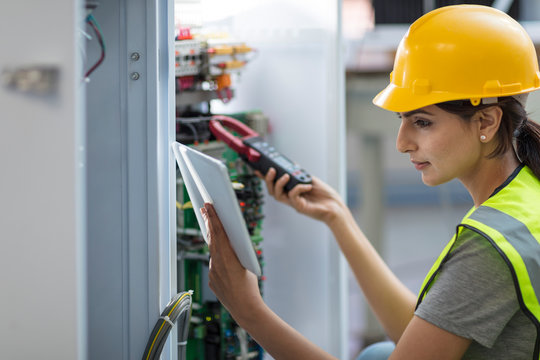 Female technician working on a box with circuit boards