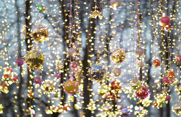 Multicolored christmas balls and garlands hanging on the street