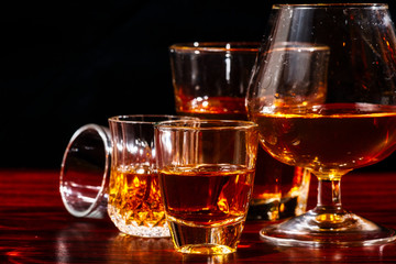 Brandy or liquor,Set of strong alcoholic drinks in glasses and shot glass on dark wood background
